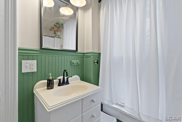 2803 Spielman Rd, Adrian, MI 49221 - bathroom with vanity, a wainscoted wall, a decorative wall, and shower / bathtub combination with curtain