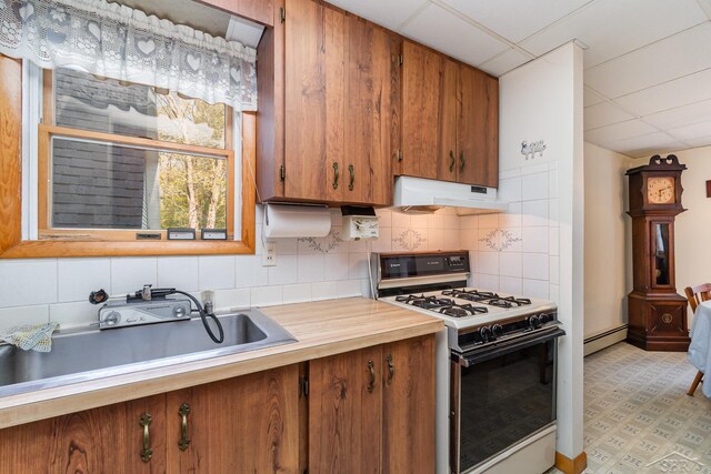 5295 E 14th St, Au Gres, MI 48703 - kitchen featuring white range with gas cooktop, under cabinet range hood, baseboard heating, a sink, and light countertops