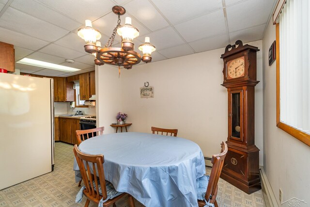 5295 E 14th St, Au Gres, MI 48703 - dining room featuring light flooring, a drop ceiling, baseboard heating, and a chandelier