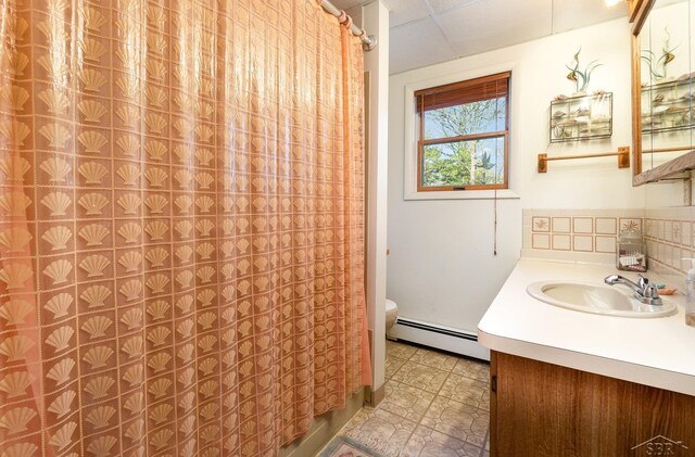 5295 E 14th St, Au Gres, MI 48703 - full bathroom featuring a baseboard heating unit, vanity, toilet, and a shower with curtain