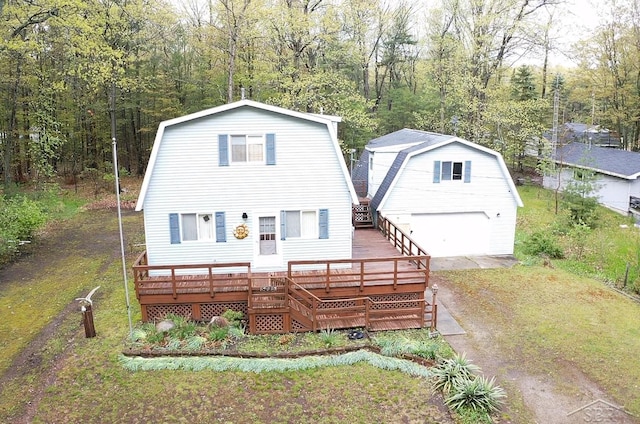 5295 E 14th St, Au Gres, MI 48703 - rear view of property featuring a gambrel roof, an outdoor structure, a detached garage, and a wooden deck