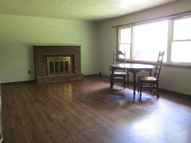 9303 County Road 653, Gobles, MI 49055 - dining area featuring hardwood / wood-style floors, healthy amount of natural light, a textured ceiling, and a brick fireplace