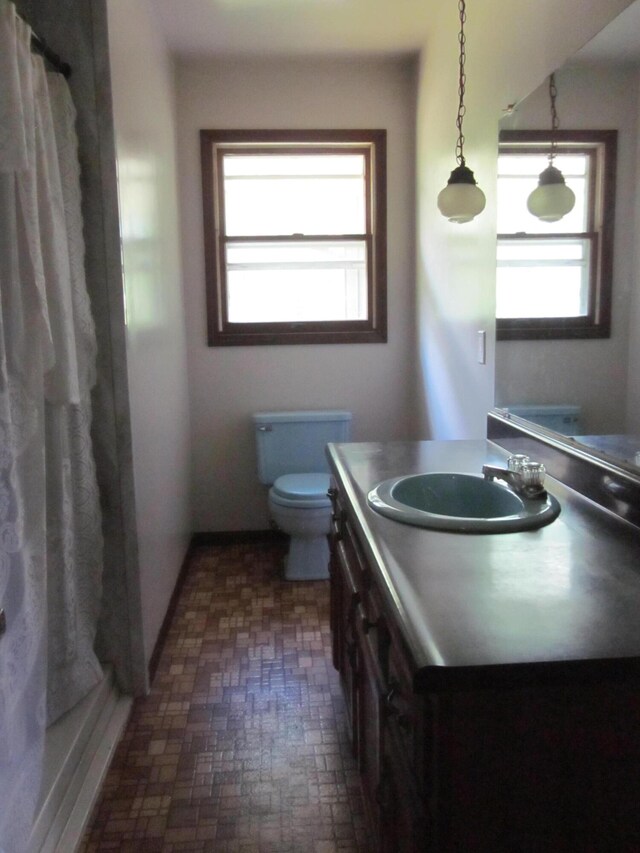 9303 County Road 653, Gobles, MI 49055 - bathroom featuring toilet, vanity, brick patterned flooring, and a shower with curtain