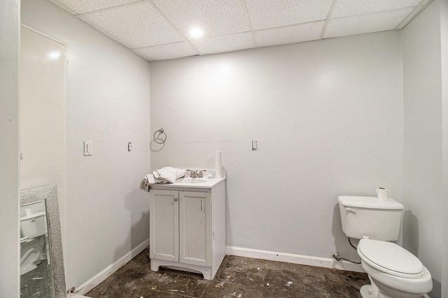 1981 E Wolf Rd, Hart, MI 49420 - bathroom with toilet, vanity, baseboards, a drop ceiling, and unfinished concrete floors