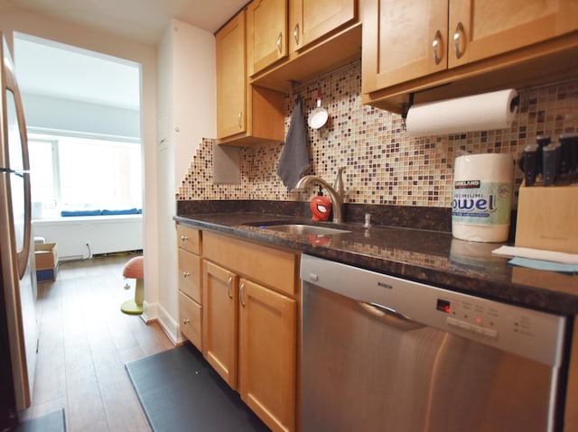 555 E William St Unit 5C, Ann Arbor, MI 48104 - kitchen with appliances with stainless steel finishes, tasteful backsplash, a sink, dark stone countertops, and light wood-style floors