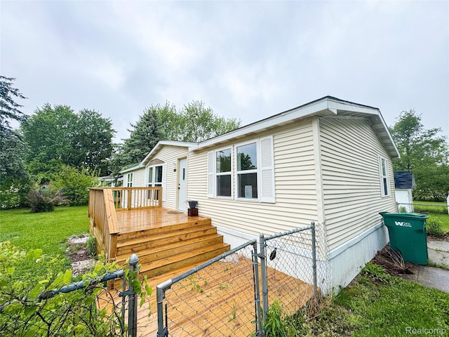 8909 E Country Ln, Lennon, MI 48449 - view of property exterior featuring a wooden deck, a lawn, and a gate