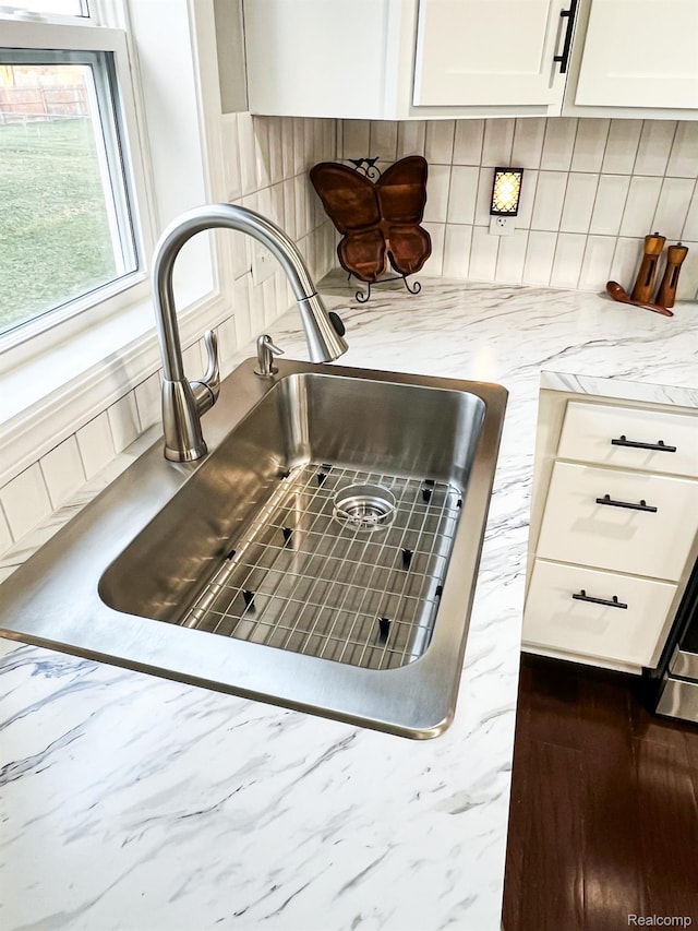 8909 E Country Ln, Lennon, MI 48449 - kitchen view of a sink, decorative backsplash, light stone counters, and white cabinetry