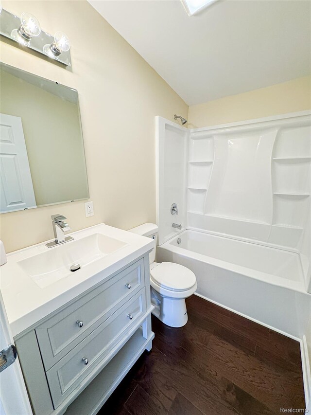 8909 E Country Ln, Lennon, MI 48449 - bathroom featuring vanity, wood finished floors, toilet, shower / bathtub combination, and lofted ceiling