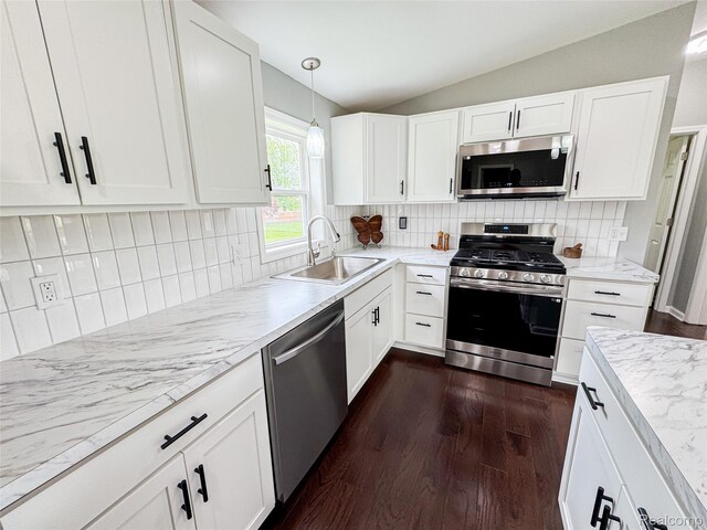 8909 E Country Ln, Lennon, MI 48449 - kitchen featuring appliances with stainless steel finishes, a sink, lofted ceiling, dark wood finished floors, and white cabinets