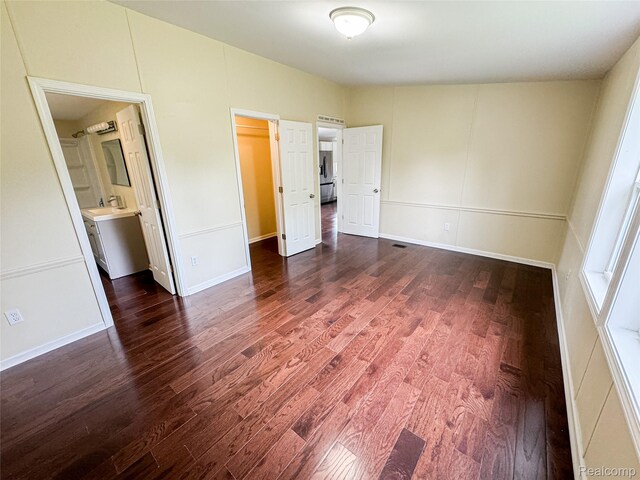8909 E Country Ln, Lennon, MI 48449 - unfurnished bedroom featuring wood finished floors, a sink, connected bathroom, and baseboards