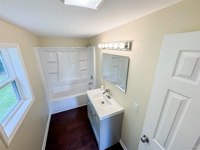 8909 E Country Ln, Lennon, MI 48449 - bathroom featuring vanity, wood finished floors, bathtub / shower combination, and baseboards