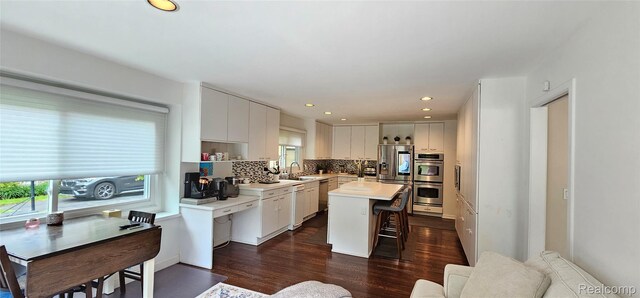 5084 Champlain Cir W, Bloomfield, MI 48323 - kitchen with stainless steel appliances, a breakfast bar area, a sink, dark wood finished floors, and a kitchen island