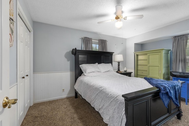 4239 Glen Hollow Dr, Hudsonville, MI 49426 - bedroom featuring carpet flooring, a textured ceiling, multiple windows, a wainscoted wall, and ceiling fan