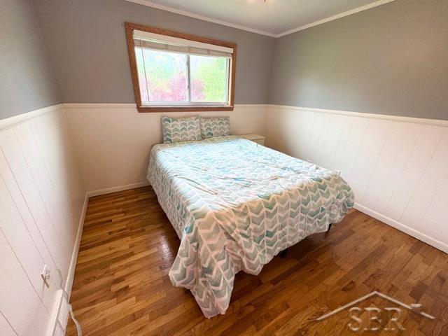 7200 Danny Dr, Saginaw, MI 48609 - bedroom with wood finished floors, wainscoting, ornamental molding, and baseboards