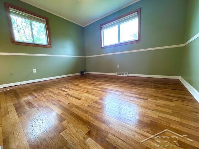 7200 Danny Dr, Saginaw, MI 48609 - spare room featuring wood finished floors, crown molding, and baseboards