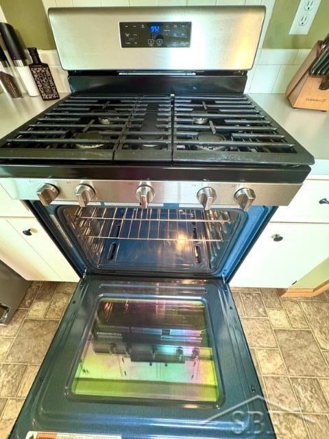 7200 Danny Dr, Saginaw, MI 48609 - kitchen view of stainless steel range with gas stovetop and decorative backsplash