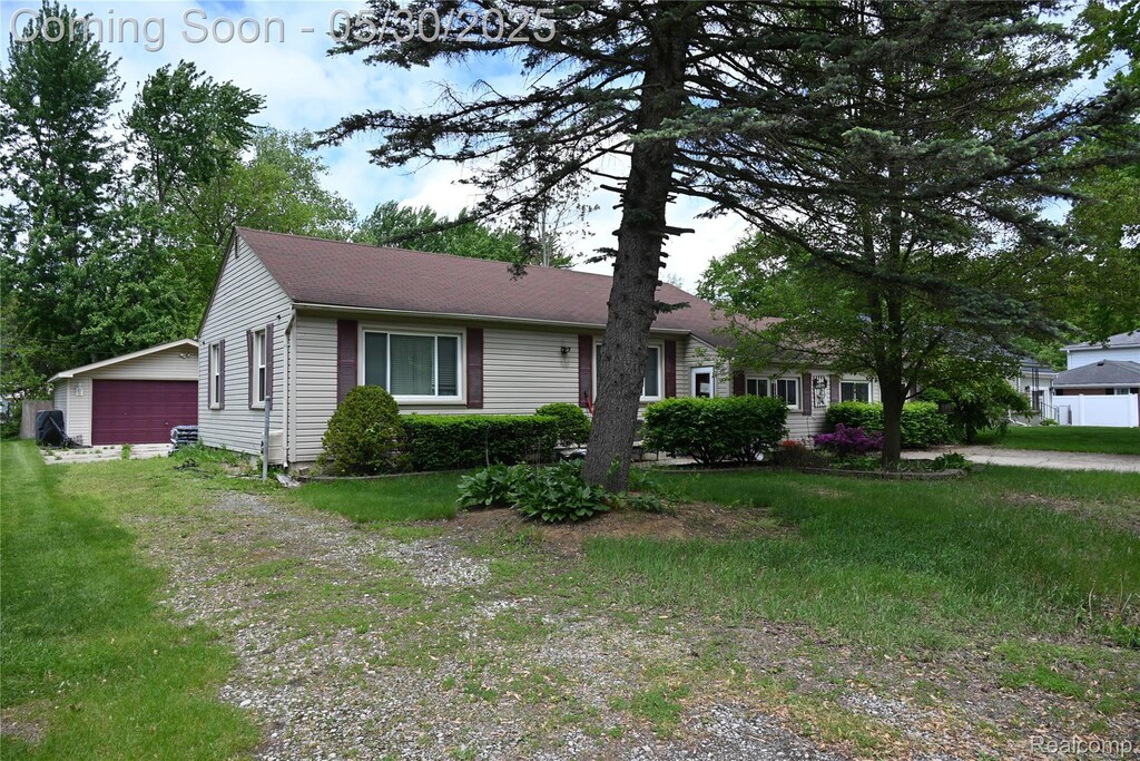 23744 Liddle St, Brownstown, MI 48183 - view of front of home featuring a detached garage, a front yard, and roof with shingles