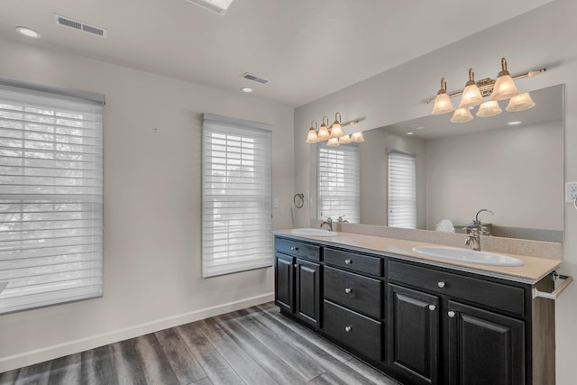 1780 Williamsburg Dr, Adrian, MI 49221 - bathroom featuring wood finished floors, double vanity, and baseboards