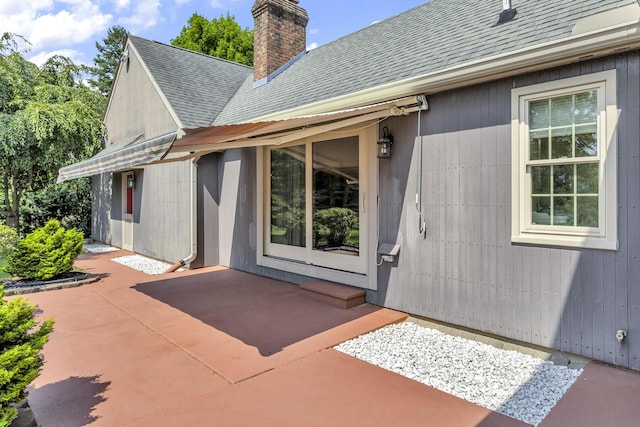 1780 Williamsburg Dr, Adrian, MI 49221 - property entrance with a shingled roof, a chimney, and a patio