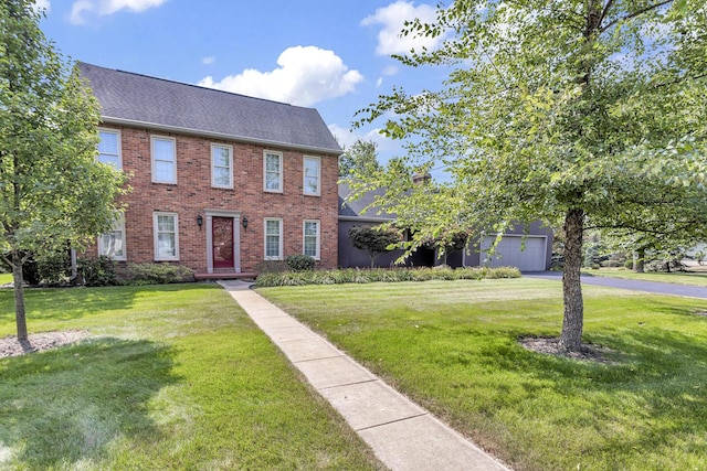 1780 Williamsburg Dr, Adrian, MI 49221 - view of front of property with brick siding, roof with shingles, a front lawn, and asphalt driveway