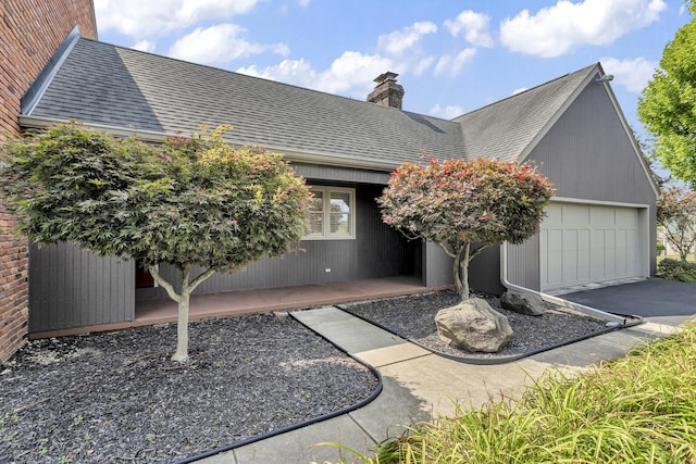 1780 Williamsburg Dr, Adrian, MI 49221 - view of front facade featuring a shingled roof, a chimney, asphalt driveway, and a garage