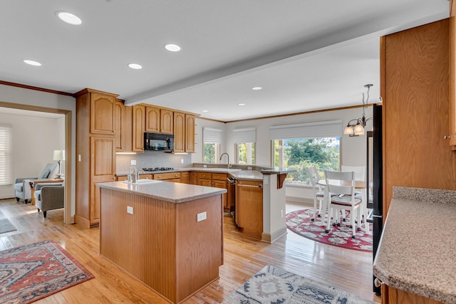 1780 Williamsburg Dr, Adrian, MI 49221 - kitchen with black microwave, a sink, a peninsula, ornamental molding, and light countertops