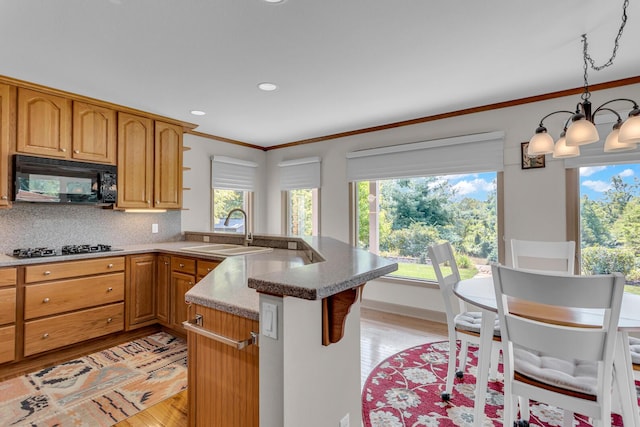 1780 Williamsburg Dr, Adrian, MI 49221 - kitchen featuring a sink, black appliances, a peninsula, light wood-style flooring, and crown molding