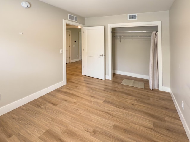 12773 Felch St, Holland, MI 49424 - unfurnished bedroom with light wood-style flooring, baseboards, and a closet