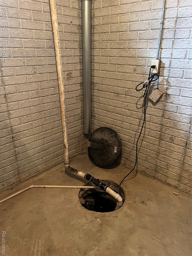4440 Colby Ct, Burton, MI 48519 - basement view of unfinished concrete flooring and brick wall