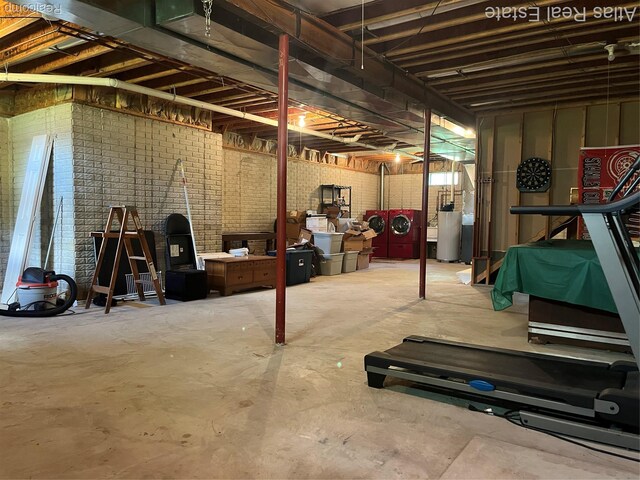 4440 Colby Ct, Burton, MI 48519 - unfinished below grade area featuring washer and clothes dryer and brick wall