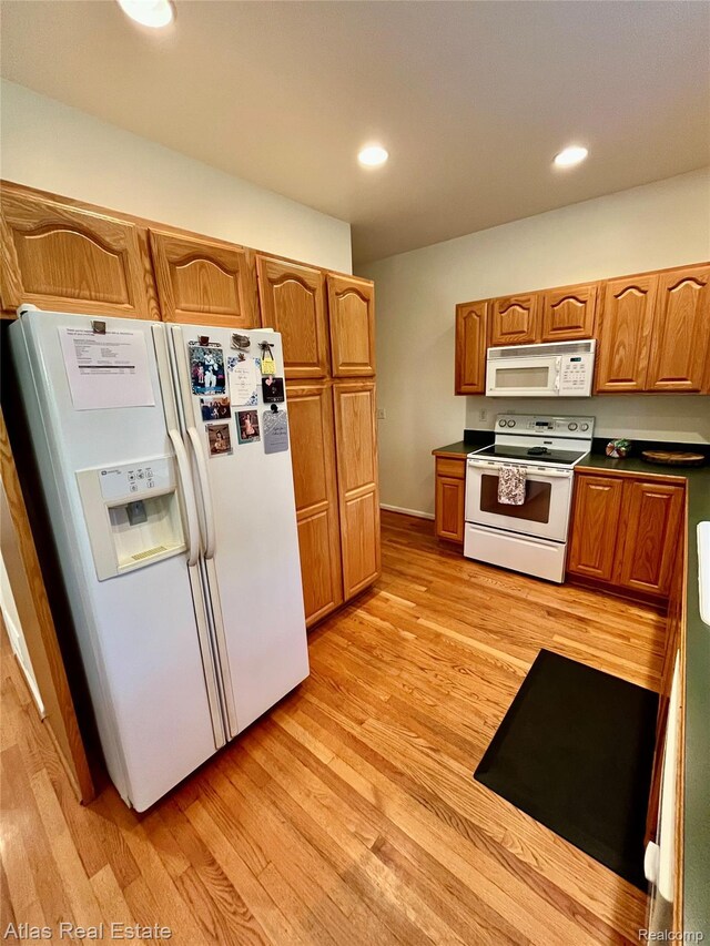 4440 Colby Ct, Burton, MI 48519 - kitchen featuring white appliances, light wood-type flooring, dark countertops, brown cabinetry, and recessed lighting