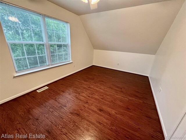 4440 Colby Ct, Burton, MI 48519 - bonus room featuring baseboards, vaulted ceiling, and wood finished floors