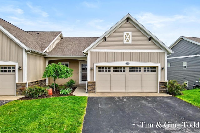 903 S Center Park Dr SW Unit 14, Byron Center, MI 49315 - view of front of house featuring stone siding, a front lawn, roof with shingles, and driveway