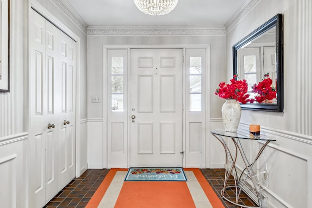 4396 Laurel Dr, Saint Joseph, MI 49085 - foyer featuring plenty of natural light, brick floors, ornamental molding, and a chandelier