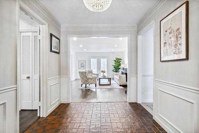 4396 Laurel Dr, Saint Joseph, MI 49085 - hall featuring a chandelier, brick flooring, french doors, wainscoting, and a decorative wall