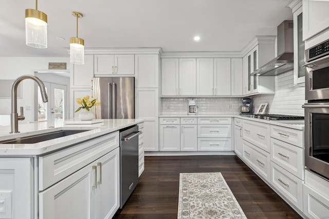 4396 Laurel Dr, Saint Joseph, MI 49085 - kitchen featuring stainless steel appliances, a sink, wall chimney range hood, white cabinets, and tasteful backsplash