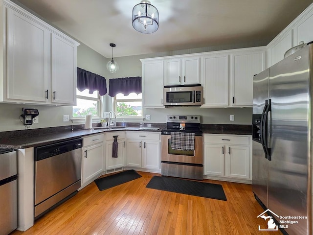 1997 Teton Ave, Monroe, MI 48162 - kitchen featuring appliances with stainless steel finishes, a sink, white cabinetry, and light wood finished floors