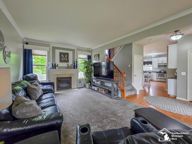 1997 Teton Ave, Monroe, MI 48162 - living room with crown molding, stairs, a fireplace with flush hearth, and light wood-style floors