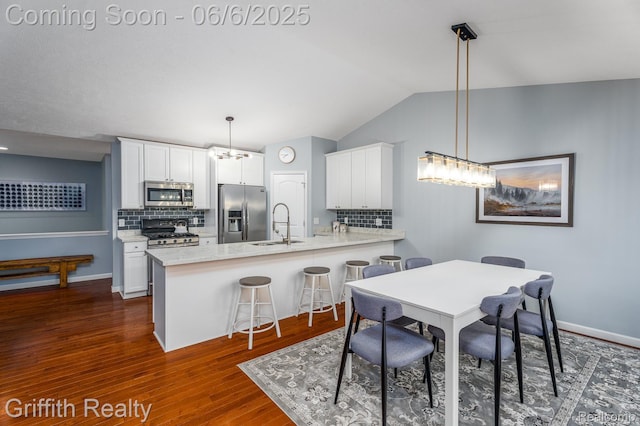 2870 Grand Marais Dr, Howell, MI 48843 - dining space with dark wood finished floors, vaulted ceiling, and baseboards