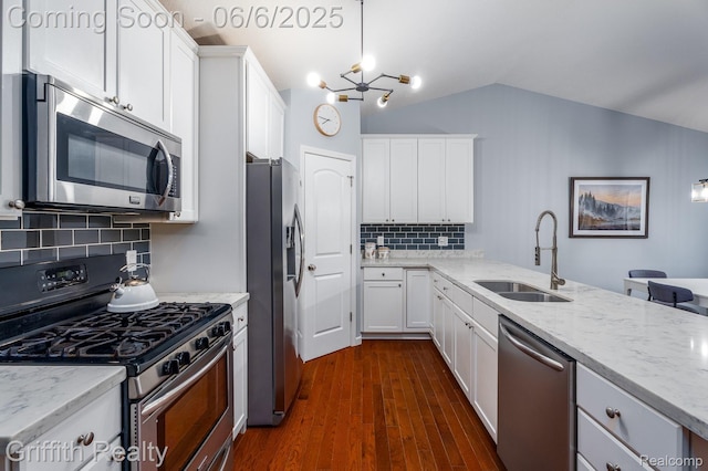 2870 Grand Marais Dr, Howell, MI 48843 - kitchen featuring appliances with stainless steel finishes, a sink, vaulted ceiling, light stone counters, and decorative backsplash