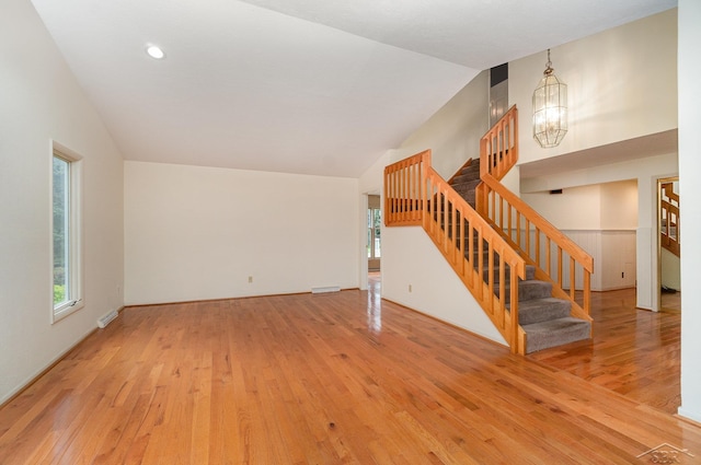 5211 S Gatesboro Dr, Saginaw, MI 48603 - unfurnished living room with stairs, hardwood / wood-style floors, a chandelier, and lofted ceiling