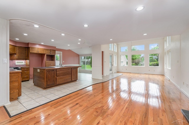 5211 S Gatesboro Dr, Saginaw, MI 48603 - kitchen with open floor plan, light wood-type flooring, brown cabinetry, recessed lighting, and an island with sink