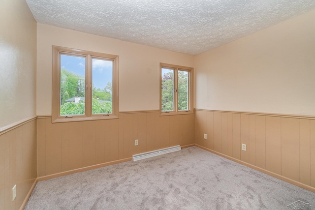 5211 S Gatesboro Dr, Saginaw, MI 48603 - empty room with a baseboard radiator, wainscoting, a textured ceiling, and carpet floors