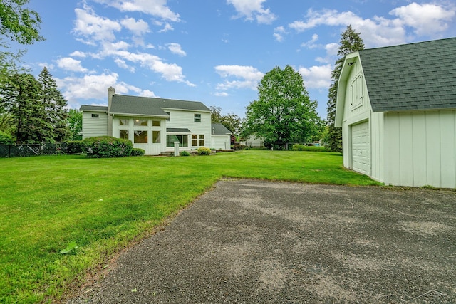 5211 S Gatesboro Dr, Saginaw, MI 48603 - rear view of property featuring roof with shingles, a chimney, an outdoor structure, and driveway
