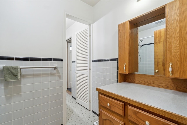 5371 Durwood Dr, Swartz Creek, MI 48473 - bathroom featuring tile walls, vanity, wainscoting, and tile patterned floors