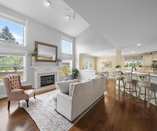 1150 Heatherlea Ct, Canton, MI 48188 - living area with high vaulted ceiling, a brick fireplace, dark wood-style flooring, a chandelier, and recessed lighting