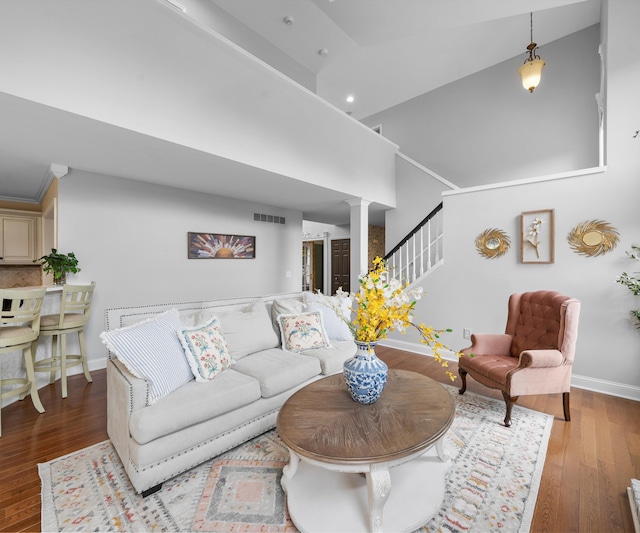 1150 Heatherlea Ct, Canton, MI 48188 - living area featuring decorative columns, baseboards, high vaulted ceiling, wood finished floors, and stairway
