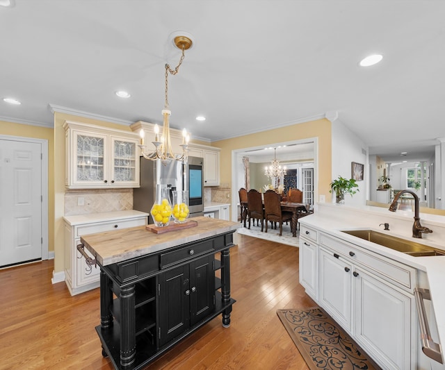 1150 Heatherlea Ct, Canton, MI 48188 - kitchen featuring a chandelier, stainless steel refrigerator with ice dispenser, a sink, dark cabinetry, and tasteful backsplash