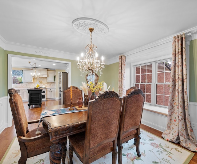 1150 Heatherlea Ct, Canton, MI 48188 - dining area with a chandelier, light wood-style floors, crown molding, and a wainscoted wall