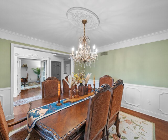 1150 Heatherlea Ct, Canton, MI 48188 - dining area featuring a chandelier, wood finished floors, ornamental molding, and wainscoting